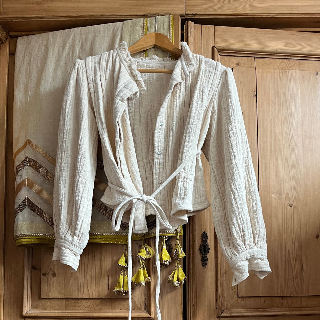 White garment on a hanger against a wooden cabinet background